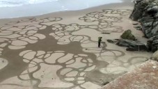 Andres Amador vytváří ručně obrazce v písku