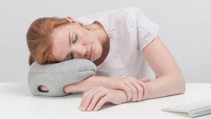 Ostrich Pillow Mini je návlek na ruku pro spaní na stolech