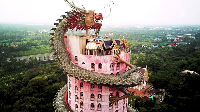 Thajský chrám má růžovou fasádu omotanou velkou sochou draka
