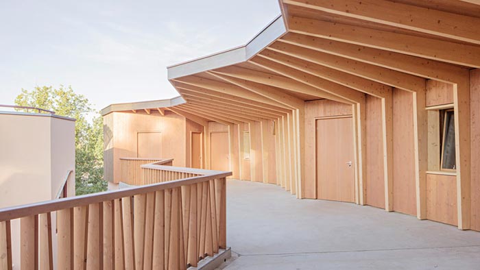 Dřevěná škola v Ženevě má místo chodeb ochozy podepřené sloupy z betonu