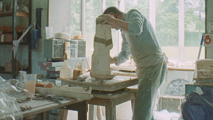 Philip Eglin vytváří z hlíny ve svém ateliéru sochy spojující dávnou historii se současností